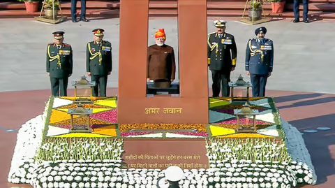 "PM Modi’s Republic Day Attire: Yellow-Red Striped ‘Safa’ with Long Veil and Brown Jacket"